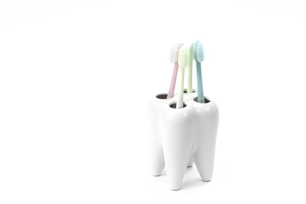 Toothbrush stand shaped like primary tooth with colorful toothbrushes — Stock Photo, Image