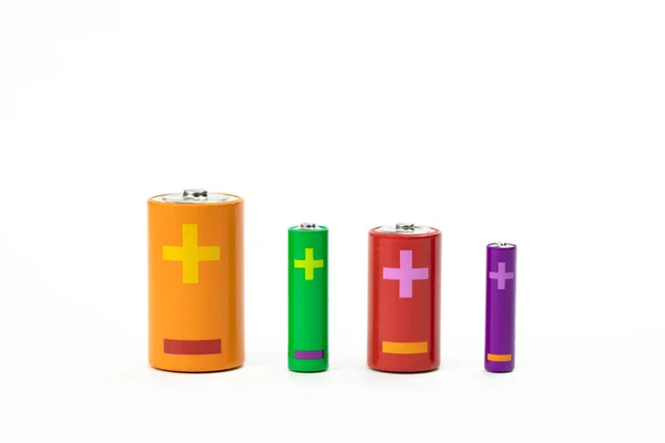 Fyra färgglada batterier i olika storlekar isolerade på vitt. Återvinningskoncept — Stockfoto