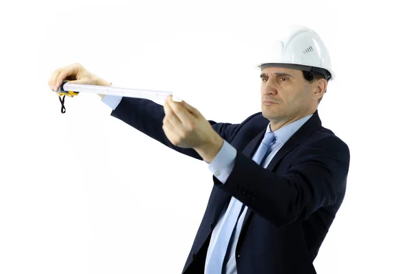 Ingenieur mit weißem Helm und offizieller Kleidung hält Maßband in der Hand Stockbild
