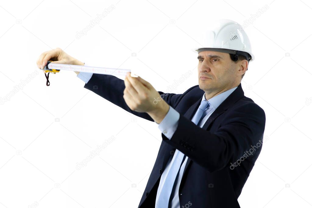 focused engineer builder in white helmet and formal clothing holds tape measure