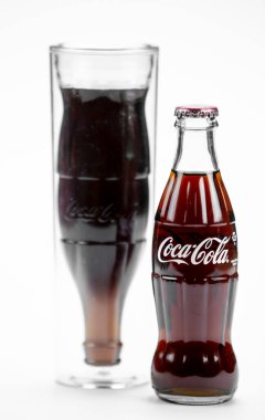 Atlanta, Georgia, ABD 1 Nisan 2020: ABD 'den izole edilmiş klasik Coca-Cola şişesi ve ters çevrilmiş Coca-Cola şişesi şeklinde biçimlendirilmiş cam bardak.