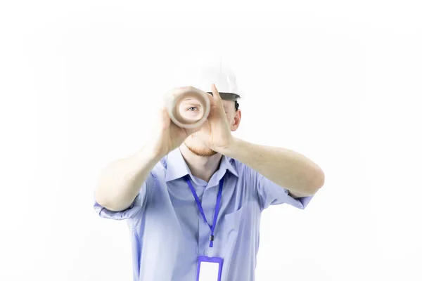 Positive young engineer holds rolled-up drawing like spyglass looks at camera — Stock Photo, Image