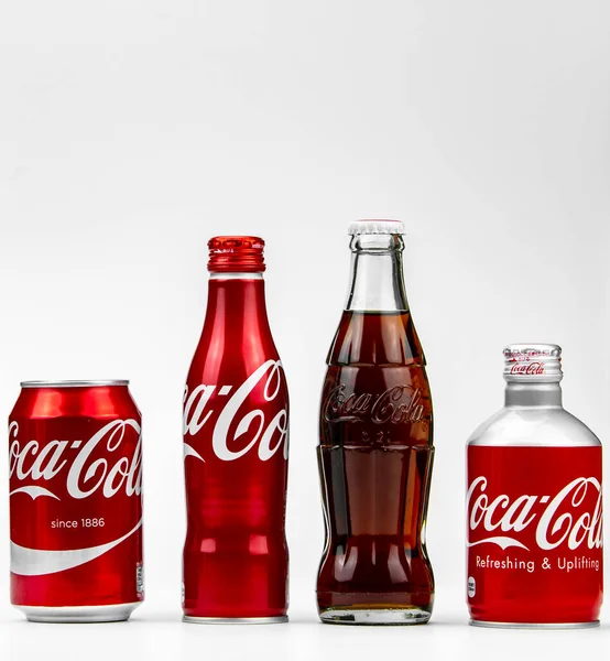 Атланта, Джорджия, США 1 апреля 2020 года: четыре разных типа банок и бутылок Coca-Cola - ностальгическая, классическая, редкая, алюминиевая концепция крупного плана, изолированная на белом фоне . — стоковое фото