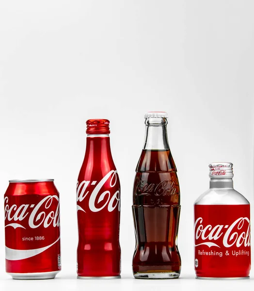 Атланта, Джорджия, США 1 апреля 2020 года: четыре разных типа банок и бутылок Coca-Cola - ностальгическая, классическая, редкая, алюминиевая концепция разнообразия, изолированная на белом фоне . — стоковое фото