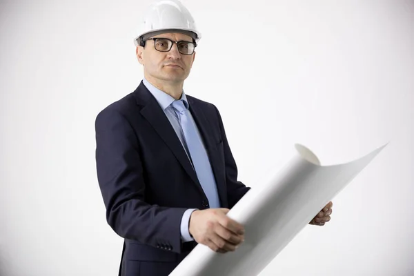 Ingeniero seguro y tranquilo en casco blanco sostiene el dibujo mira a la cámara —  Fotos de Stock
