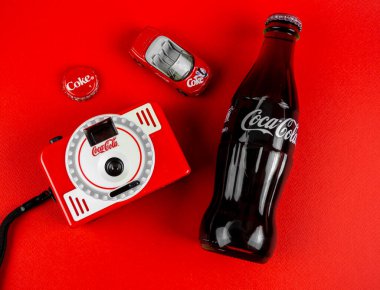 Atlanta, Georgia, ABD 1 Nisan 2020: Coca-Cola kontur şişesi, kapak, marka kamera Vintage ölüm oyuncağı kırmızı arka planda izole edilmiş