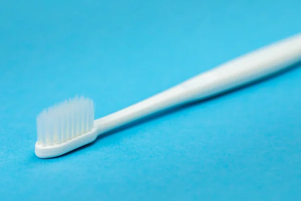 Cepillo de dientes blanco aislado sobre fondo azul diagonal — Foto de Stock