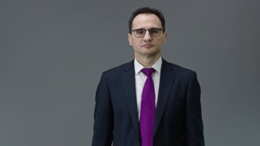 Yakışıklı orta yaşlı işadamı saat 8 'de saatini işaret ediyor.