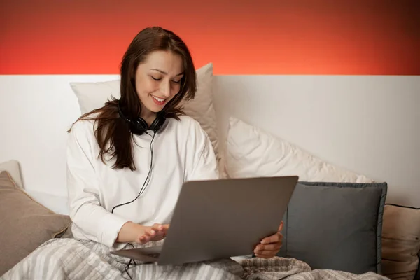 Hermoso freelancer sonriente trabajando en el portátil sentado en la cama, Trabajo remoto — Foto de Stock