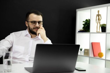 Başarılı yakışıklı işadamı ev ofisinde video görüşmesi yapıyor, uzaktan çalışma.