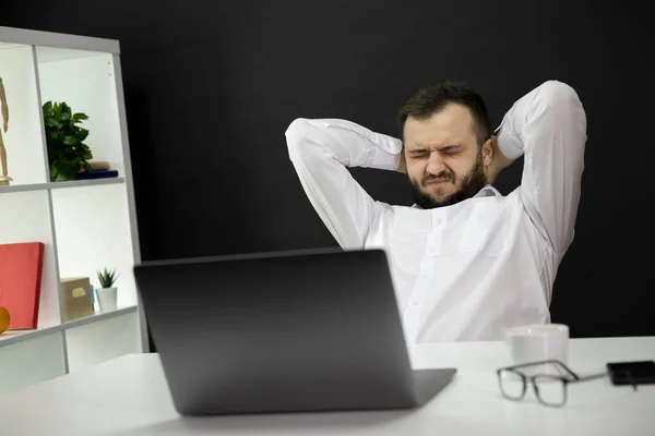 Empresário bonito sobrecarregado em camisa branca com olhos fechados e mãos na parte de trás da cabeça cansado de trabalho freelance remoto, esgotamento, problemas financeiros, falta de clientes e conceito de pedidos — Fotografia de Stock