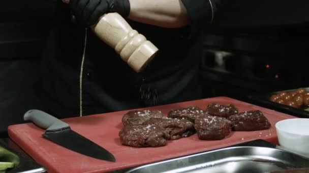 Koch würzt das Rindersteak mit Pfeffer — Stockvideo