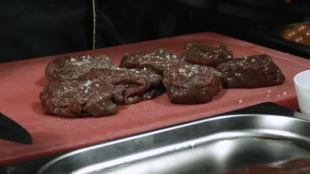 Vařit přidání olivový olej na hovězí steaky zavřít — Stock video