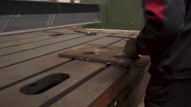 Elle metal kesme, kıvılcım akışı ve alev meşalesi. Endüstriyel üretim. Koruyucu maskeli kaynakçı