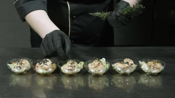 Koken van een garnalensalade, versiert de salade met kruiden. — Stockvideo