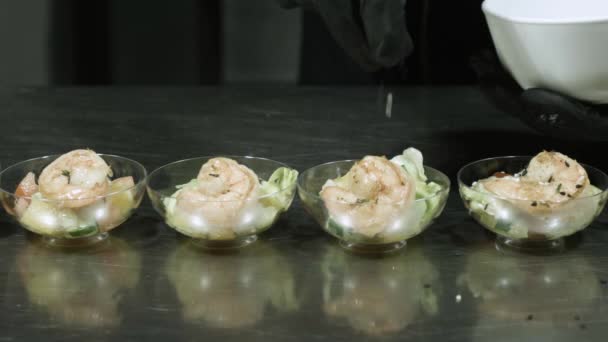 Cocinar haciendo una ensalada de camarones, añadiendo semillas de sésamo, decora la ensalada con hierbas . — Vídeos de Stock