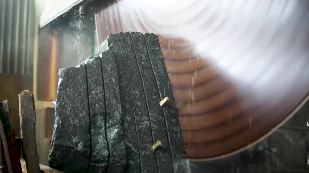 Μεγάλος βιομηχανικός πετροκόφτης κόβει γρανίτη σε πλάκες σε πίδακες νερού κοντά σε χαμηλή γωνία — Αρχείο Βίντεο