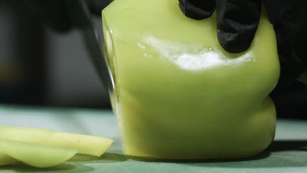 Cooks händer i svarta handskar skivning paprika närbild selektivt fokus — Stockvideo