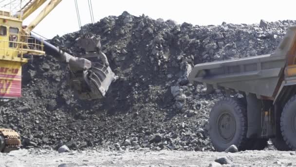 Mikashevichi, Belarus, 14.04.2020 - Large excavator loading granite into heavy dump truck Belaz — Stock Video