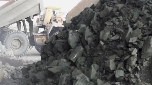 Zware dump trucks Belaz lossen granieten stenen op de granieten breeklijn slow motion — Stockvideo