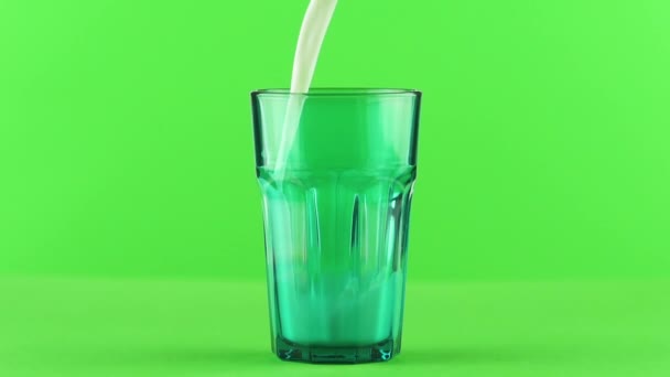 Молоко льется в огранённое зеленое стекло, изолированное на светло-зеленом фоне. — стоковое видео