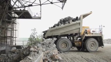 Ağır damperli kamyonlar Belaz granit taşları ağır çekimde ezer.