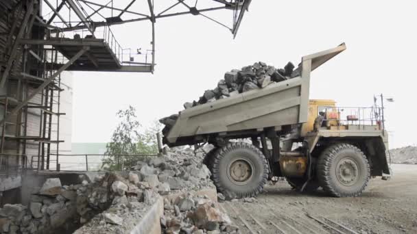 Camiones volquete pesados Belaz descargar piedras de granito en la línea de trituración de granito cámara lenta — Vídeo de stock