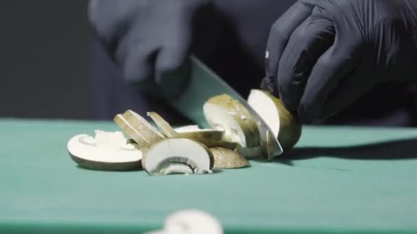 Cozinheiros mãos em luvas pretas cortando cogumelos de perto — Vídeo de Stock
