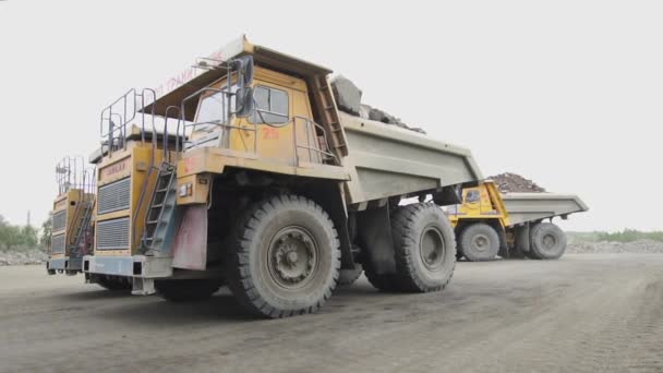 Mikashevichi, Bielorrússia, 14.04.2020 - caminhões basculantes Belaz descarregam pedras de granito na linha de trituração de granito câmera lenta — Vídeo de Stock