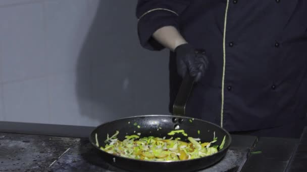 Cook cooking vegetables in a frying pan on the stove — Stock Video