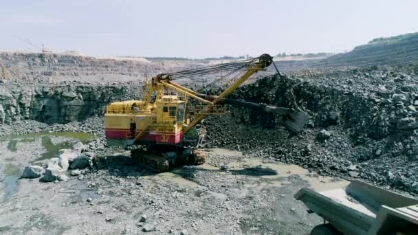 Mikashevichi, Vitryssland, 14.04.2020 - Stor grävmaskin lastar granit i tung dumper Belaz — Stockvideo