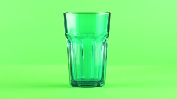 Saft in grün facettiertem Glas isoliert auf hellgrünem Hintergrund — Stockvideo