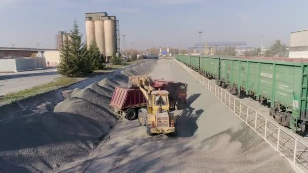 建筑物流枢纽前装载机将砂砾装入倾卸卡车车体 — 图库视频影像