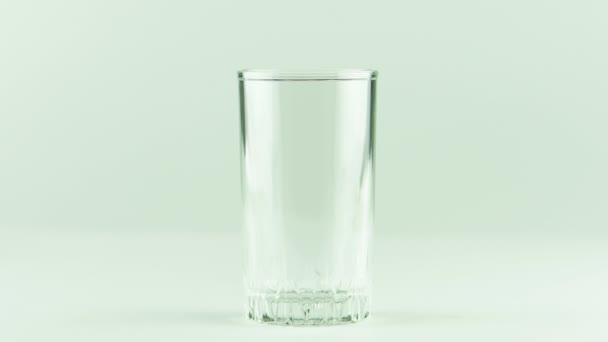 白い背景に隔離されたガラスに注ぐジュース — ストック動画