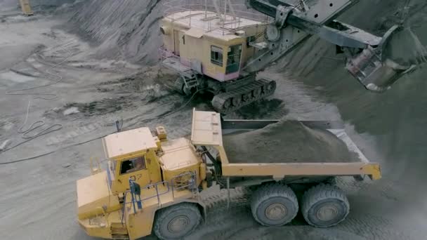 Mikashevichi, Bielorrusia, 14.04.2020 - Excavadoras de equipos de minería pesada, camiones volquete grandes, cargadoras frontales que trabajan en la producción de piedra triturada, vista aérea de cerca — Vídeo de stock