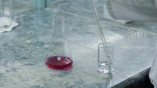 Operatör, kimyasal gösterge şişesinin önündeki ölçüm tüpünden su ya da çözelti örneği alır. — Stok video