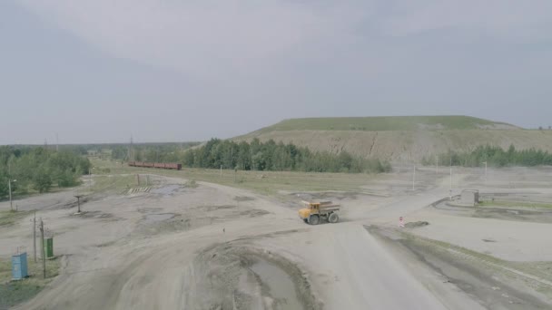 Mikashevichi, Weißrussland, 14.04.2020 - Schwerlastwagen Belaz fährt auf dem Hintergrund grüner Felsenkippen in Zeitlupe — Stockvideo