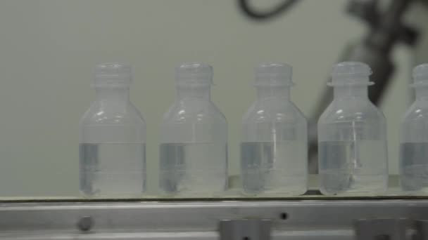 Пластиковые бутылки на медицинские растворы Транвейерная технология заполнения пломб, используемая для производства заполненных жидкостью контейнеров на медицинском или пищевом промышленном заводе вблизи — стоковое видео