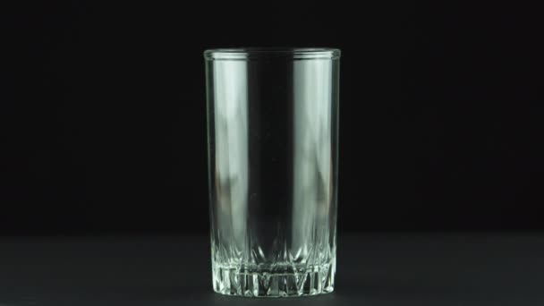 Melk gieten in glas close-up geïsoleerd op zwarte achtergrond — Stockvideo