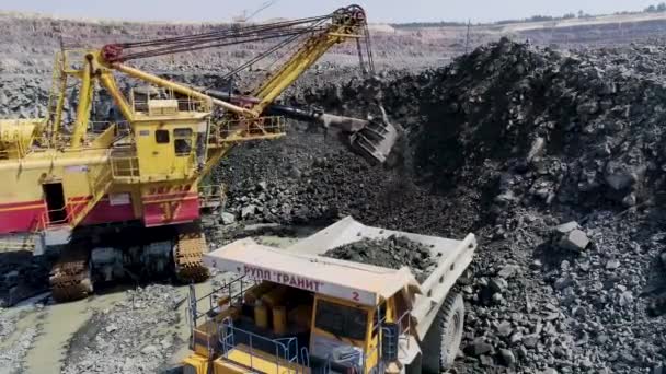 Mikashevichi, Belarus, 14.04.2020 - Large excavator loading granite into heavy dump truck Belaz — 图库视频影像