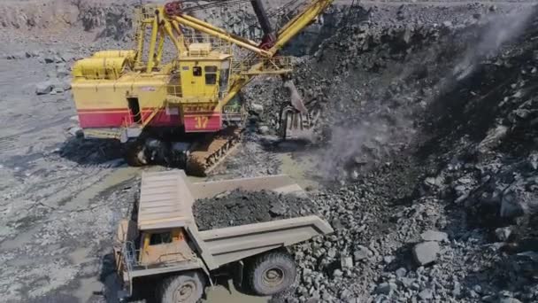 Mikashevichi, Belarus, 14.04.2020 - Grote graafmachine laden graniet in zware dump truck drone top view Hoge hoek close-up — Stockvideo