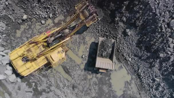 Big excavator loading granite into heavy dump truck drone top view — Stock Video