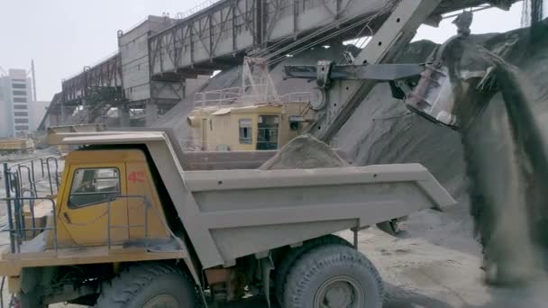 Mikashevichi, Belarus, 14.04.2020 - Graafmachines voor zware mijnbouw, grote kiepwagens, frontladers die werken aan de productie van geplette steen, luchtfoto close-up — Stockvideo