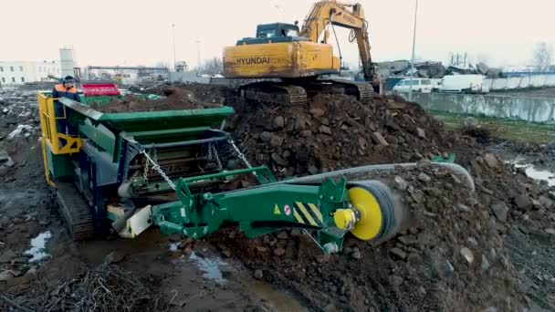 Minsk, Λευκορωσία 13.04.2020 - Βιομηχανική ανακύκλωση σκυροδέματος βαρέος κατασκευαστικού εξοπλισμού: εκσκαφέας, σταθμός σύνθλιψης σκυροδέματος που εργάζεται για την ανακύκλωση των αποβλήτων εργοταξίου — Αρχείο Βίντεο