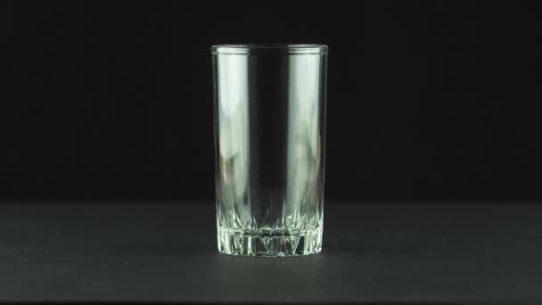 Cola wordt gegoten in glas vol bellen en schuim geïsoleerd op zwarte achtergrond — Stockvideo