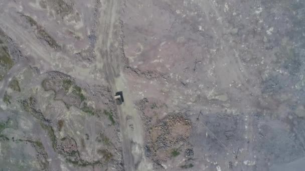 大規模な花崗岩の露天掘り鉱山でダンプトラックを採掘。ドローンハイトップビュー — ストック動画
