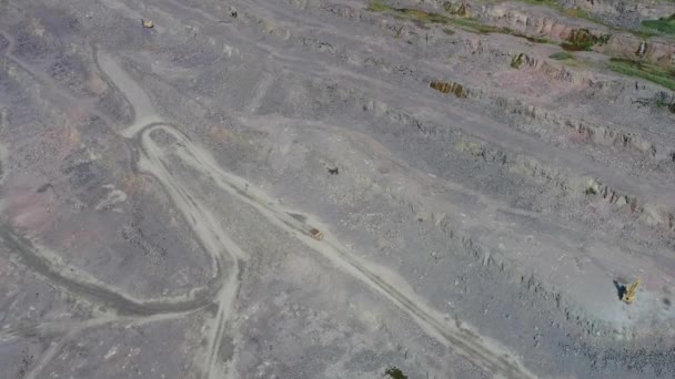 Camiones volquete mineros en gran mina de granito a cielo abierto. Drone vista superior alta — Vídeos de Stock