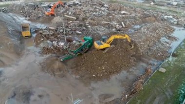 Minsk, Belarus 13.04.2020 - beton ağır inşaat ekipmanlarının geri dönüşümü: ön yükleyici, kazıcı, beton ezme istasyonu, inşaat atığı hava görüntüsünün geri dönüşümü üzerinde çalışan çöp kamyonu