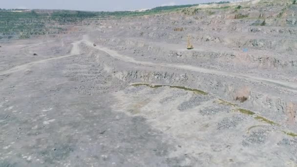 Camiones volquete mineros en gran mina de granito a cielo abierto. drone volando hacia — Vídeos de Stock