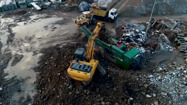 Minsk, Biélorussie 13.04.2020 - Recyclage industriel des équipements lourds en béton : chargeuse frontale, pelle, station de concassage de béton, camion à benne basculante travaillant sur le recyclage des déchets de construction vue par drone — Video